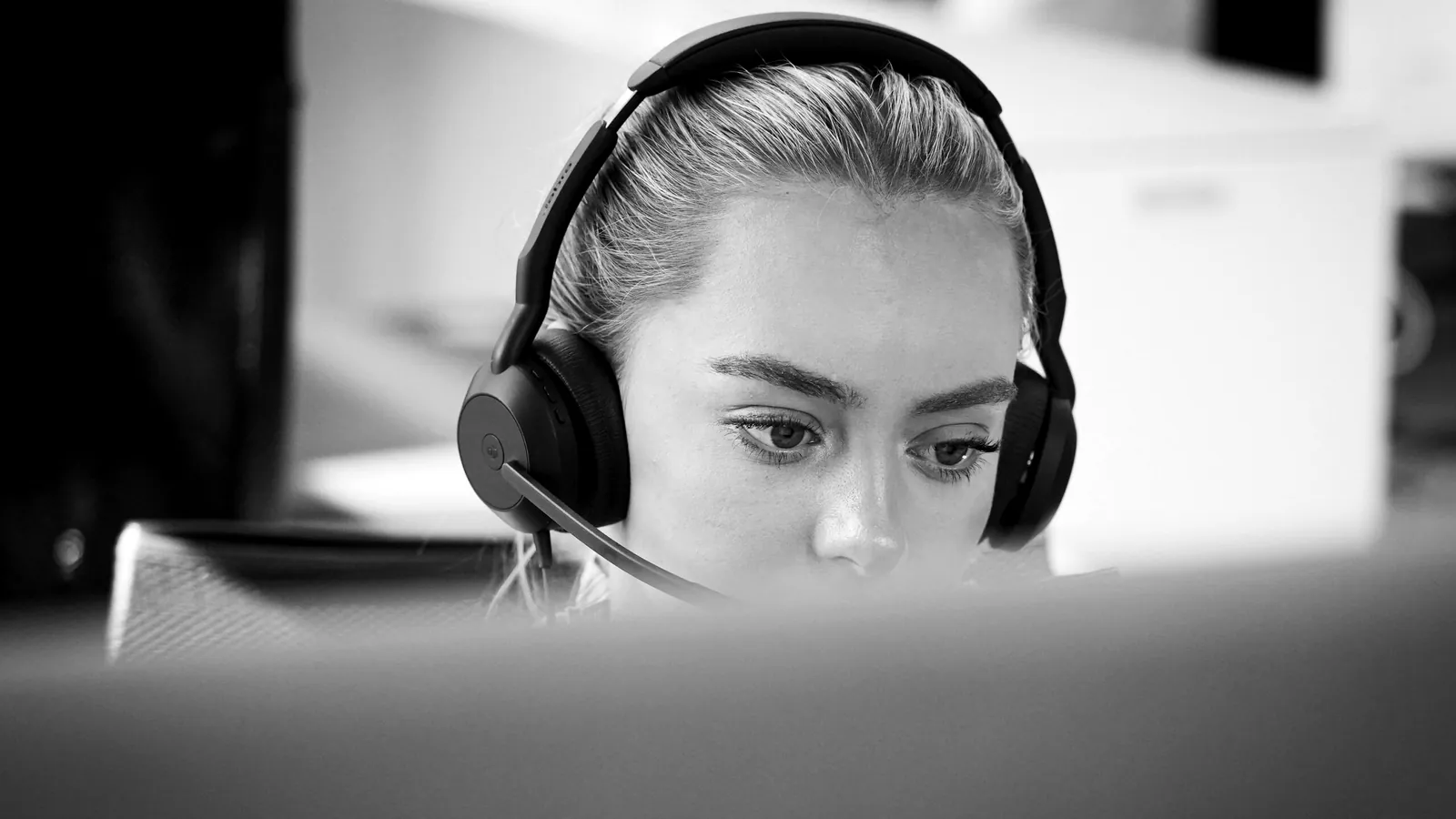 Selger med headset konsentrert foran skjermen